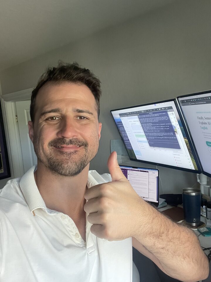 Dan, your AI coach, at his desk with the AI Coach Dan site on his monitors